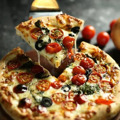 A scrumptious sausage pizza with thick dough and cheese topped with olives, tomatoes, and herbs.