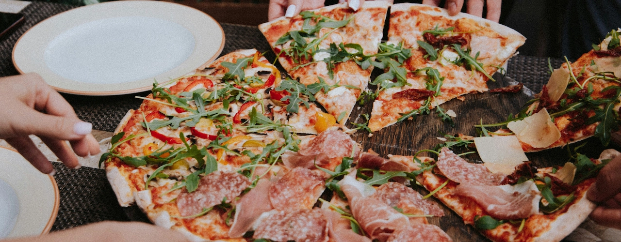 Friends eating pizza celebrating national sausage pizza day